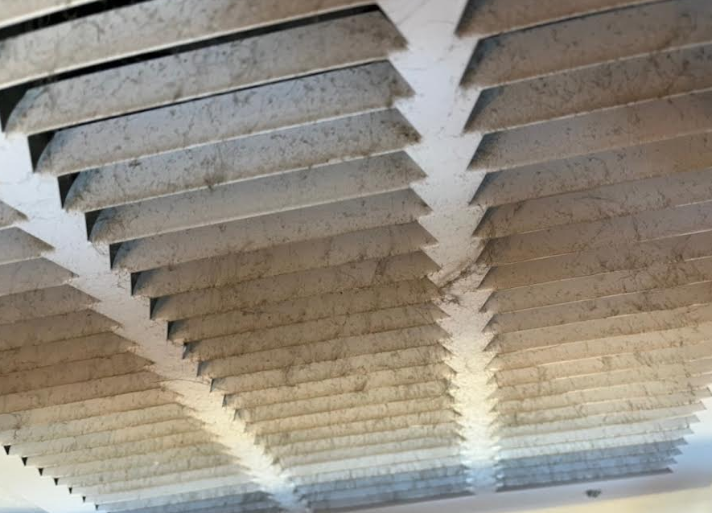 Dusty air vent covered in grime before cleaning